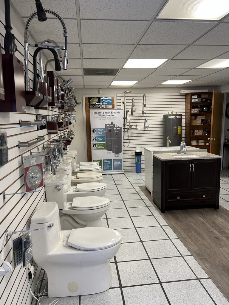 An interior view of a bathroom fixture showroom displaying various models of toilets, sinks, and other bathroom accessories in a prime commercial real estate location.